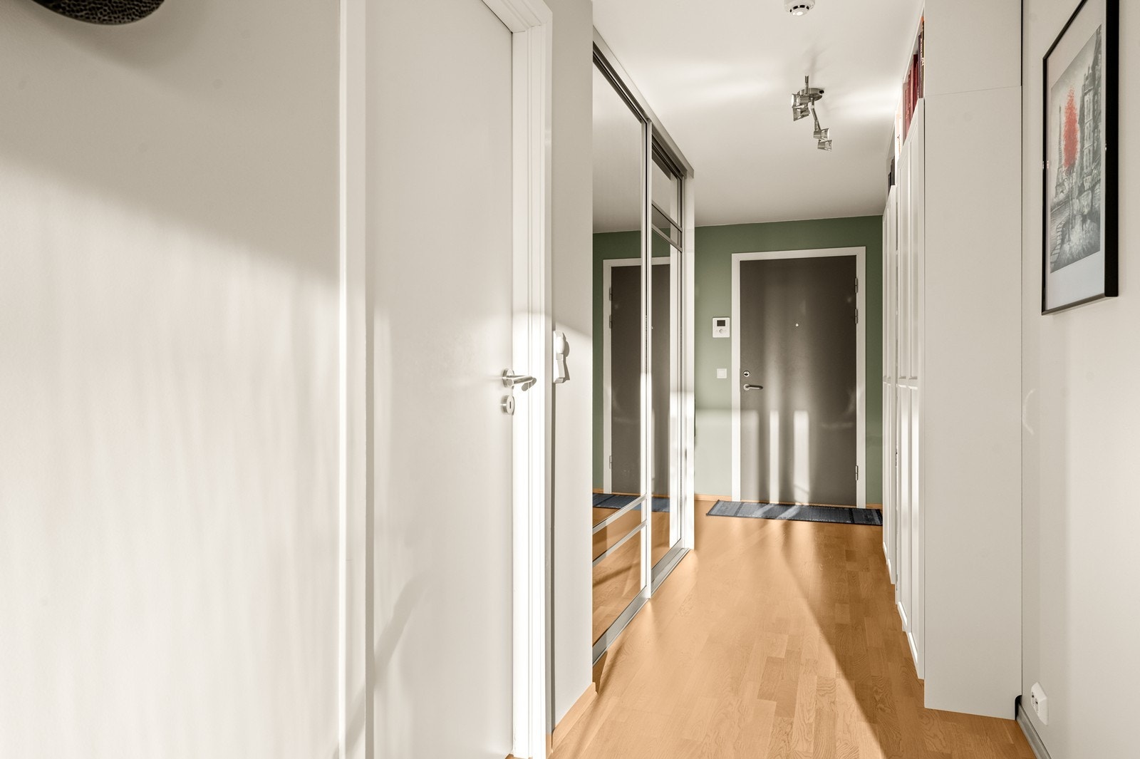 Gangen binder leilighetens rom sammen og har parkett på gulvet og malte veggflater. Galleribilde