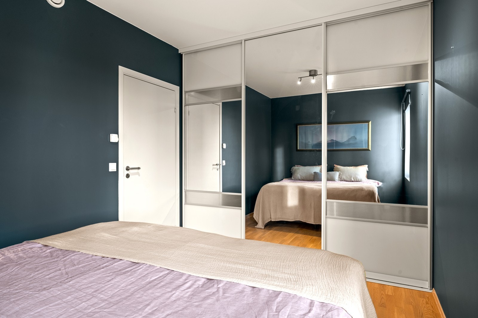 En stor skyvedørsgarderobe med speilfronter gir rikelig med oppbevaringsplass. Galleribilde