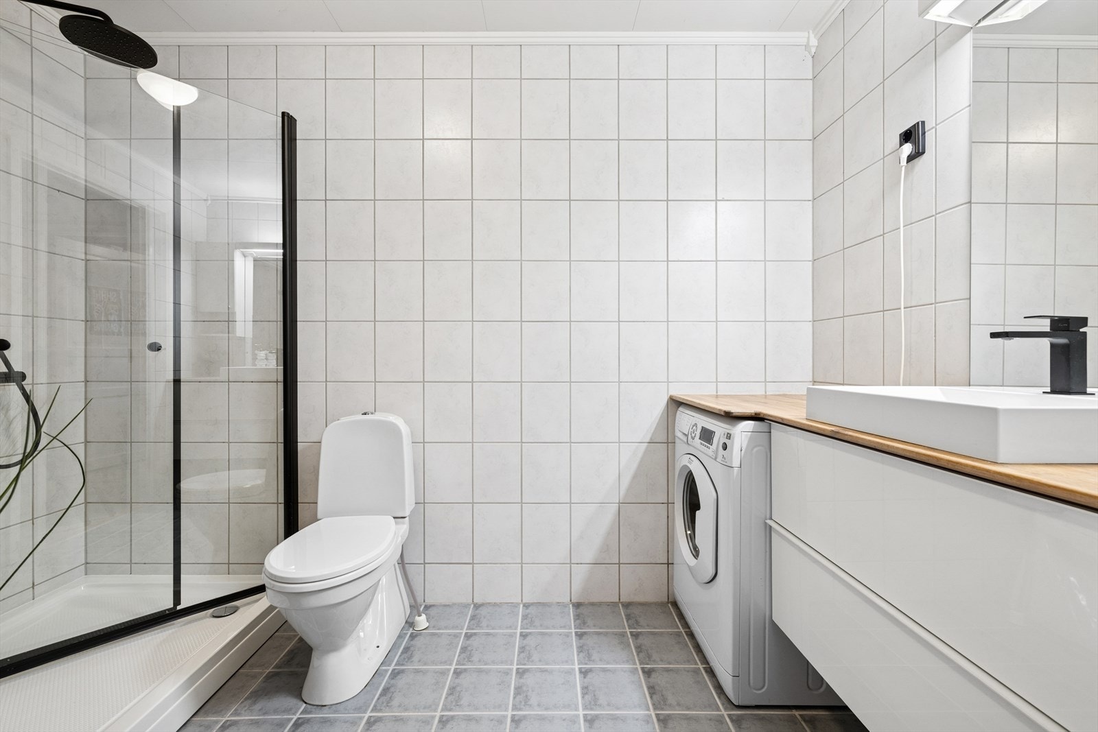 I leilighetens hovedetasje finner vi et delikat baderom med flislagt gulv og vegger. Galleribilde