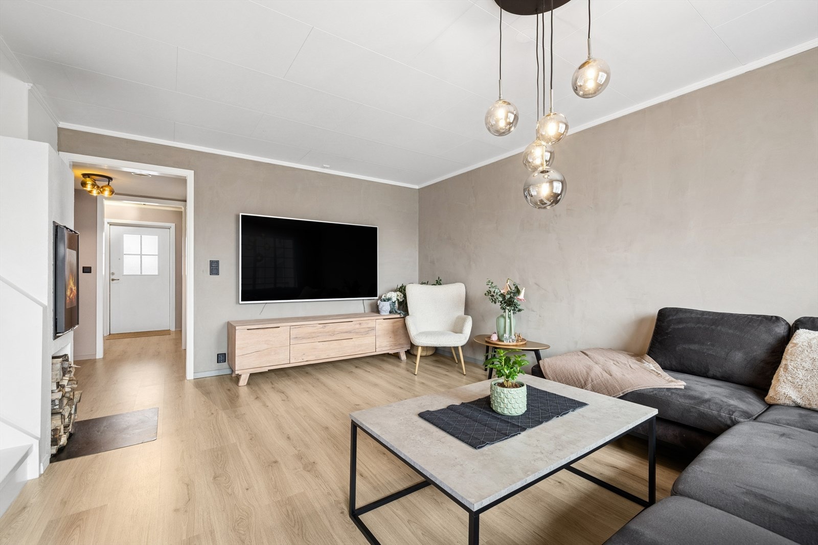 Stuen er gjennomført i en moderne fargepalett på vegger, tak og gulv med store vinduer og terrassedør med glass som slipper inn godt med dagslys. Galleribilde