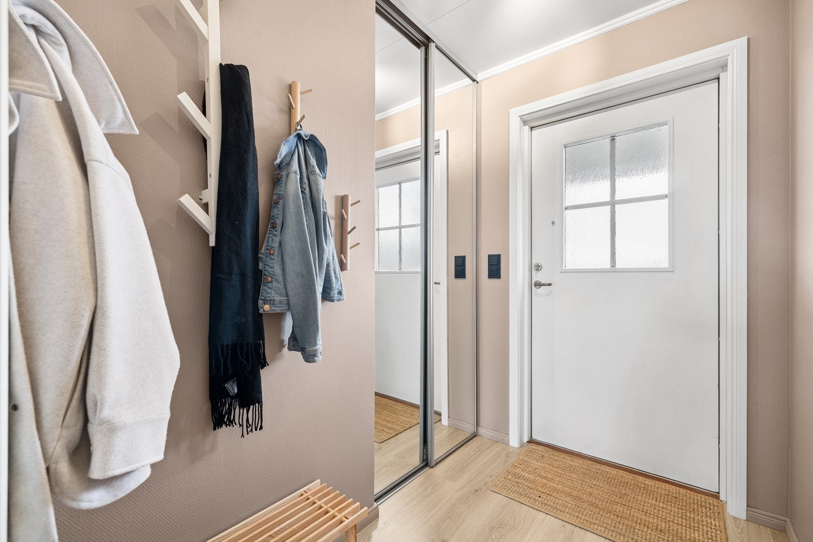 Vel innenfor inngangsdøren ønsker en romslig og lys og koselig entré deg velkommen inn med god plass til å henge og sette fra seg sko og yttertøy. Galleribilde