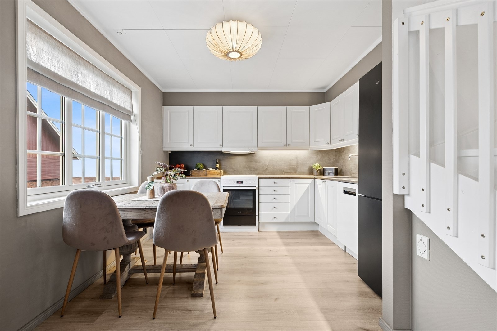 Kjøkkenet i leiligheten har åpen løsning mot stuen, med en tidløs og pen kjøkkeninnredning. Galleribilde