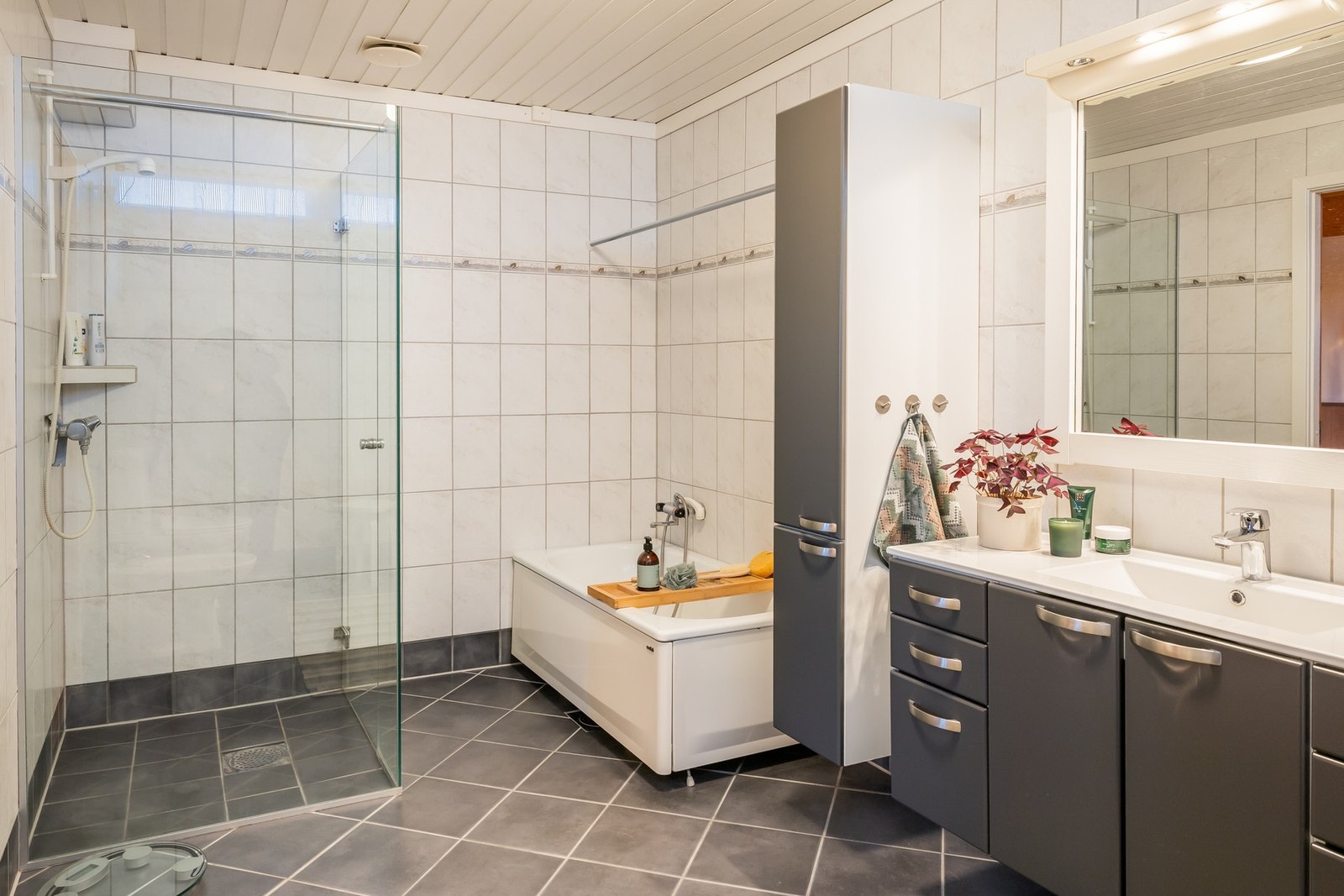 Av installasjoner er det dusjvegger av glass, dusjgarnityr på vegg, gulvmontert toalett, innredning med servant og bidé. Galleribilde