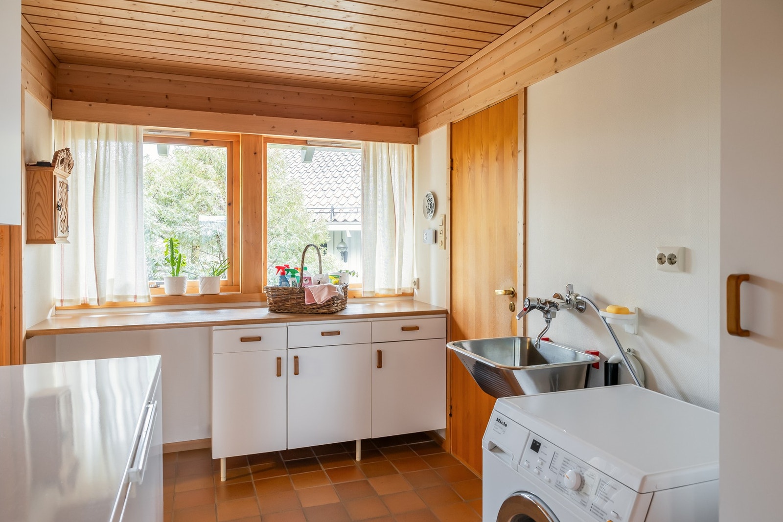 Ved kjøkken har man stort vaskerom med egen praktisk inngang. Rommet har flislagt gulv og malte strier på vegger. Galleribilde