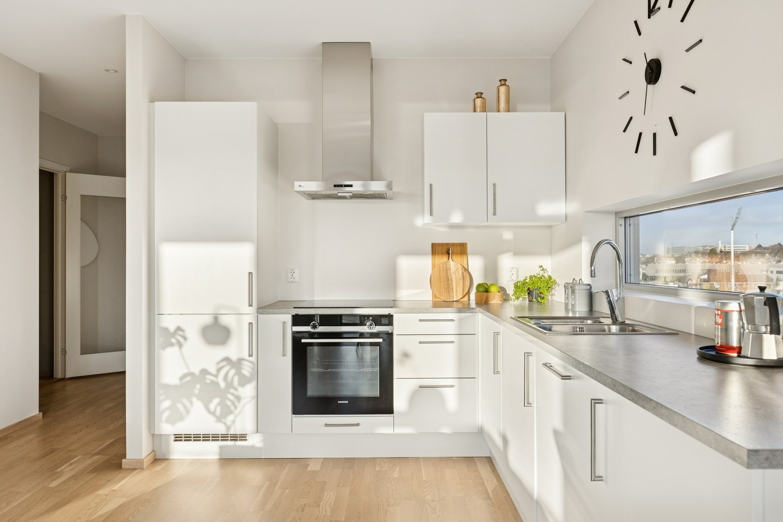 Stilrent kjøkken med lys innredning med glatte fronter. Galleribilde