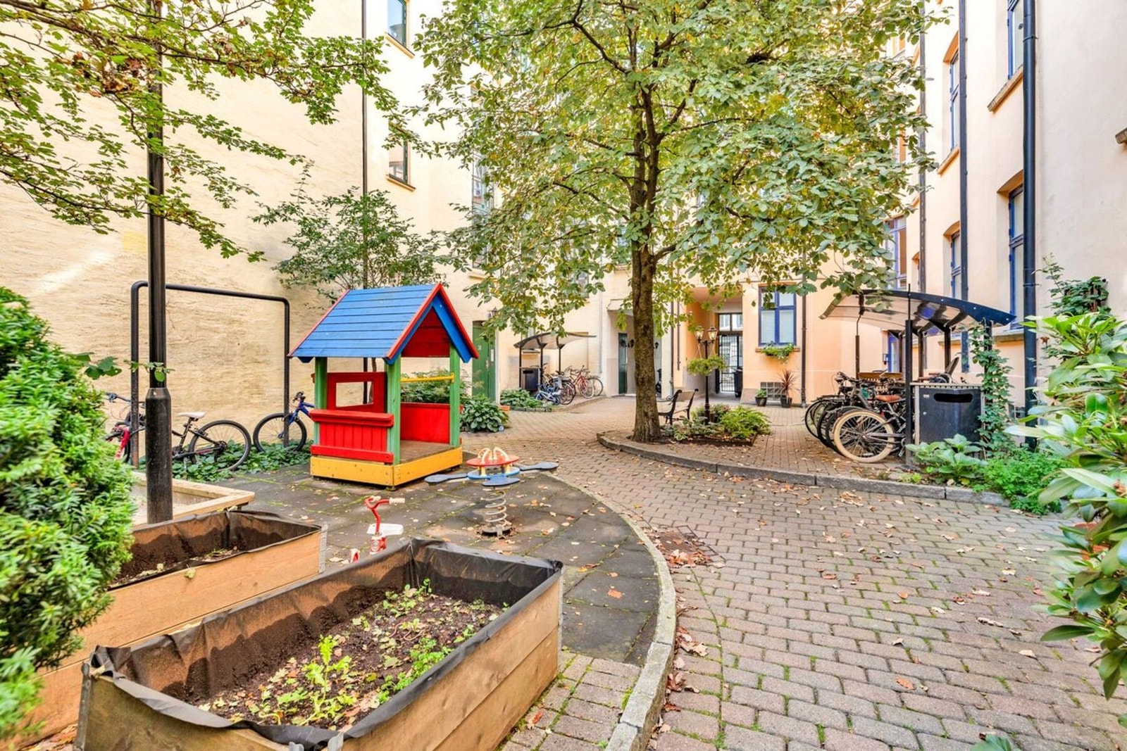 Sjarmerende og frodig bakgård med sittegrupper og grill - ekstra hyggelig på sommerstid. Galleribilde