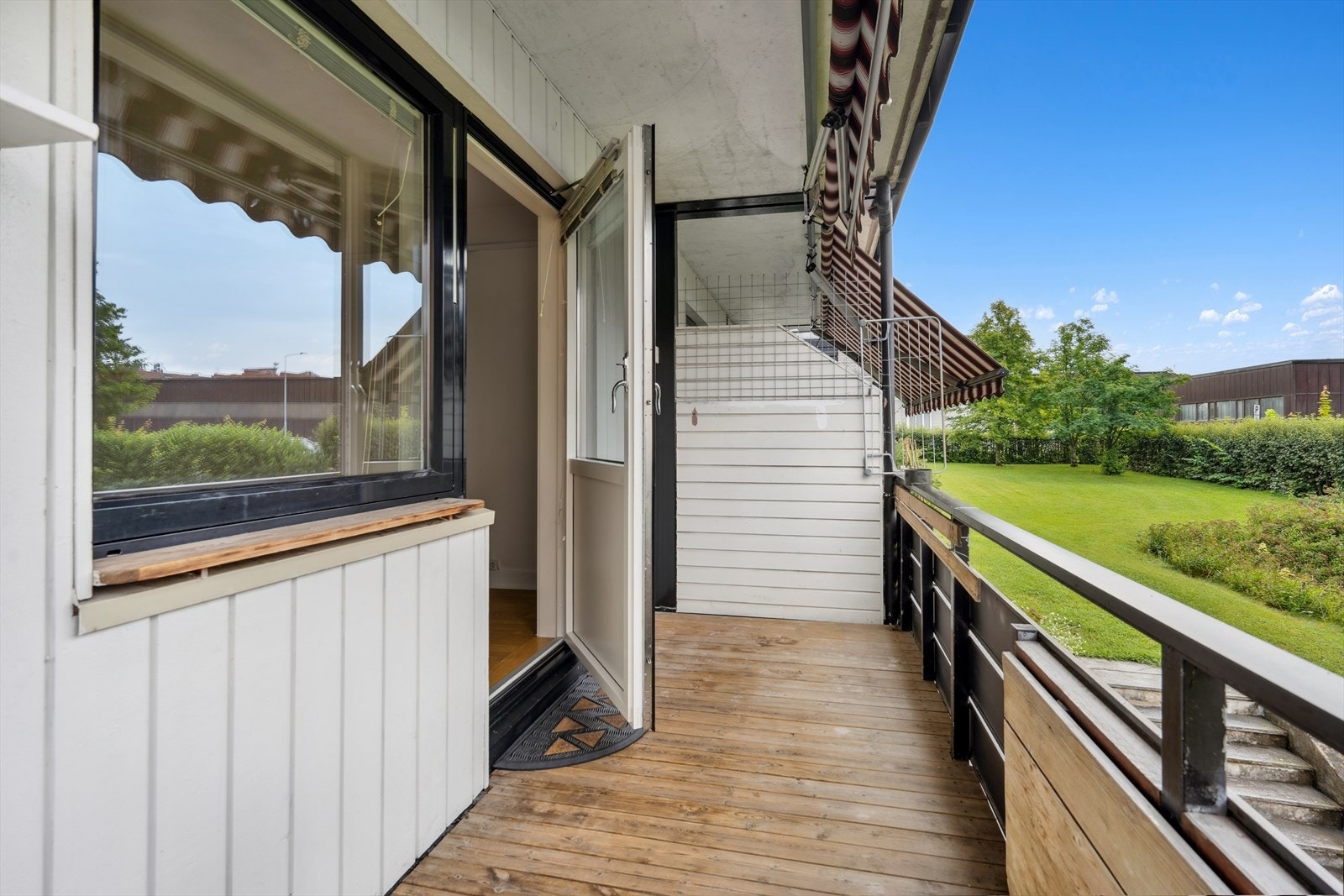 Utgang til en privat balkong med utsyn over fine fellesarealer med utplass og plass til lek for de minste Galleribilde