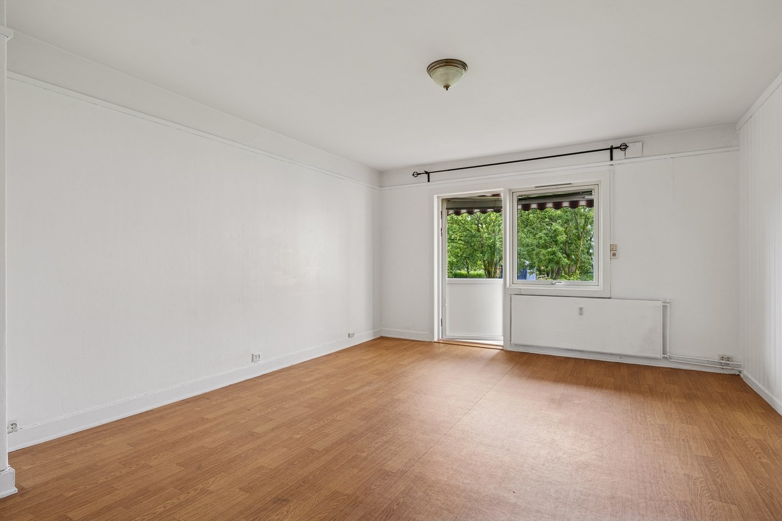 Stuen har god plass til møblering. Utgang til balkong med utsikt mot de fine, grønne fellesarealene Galleribilde