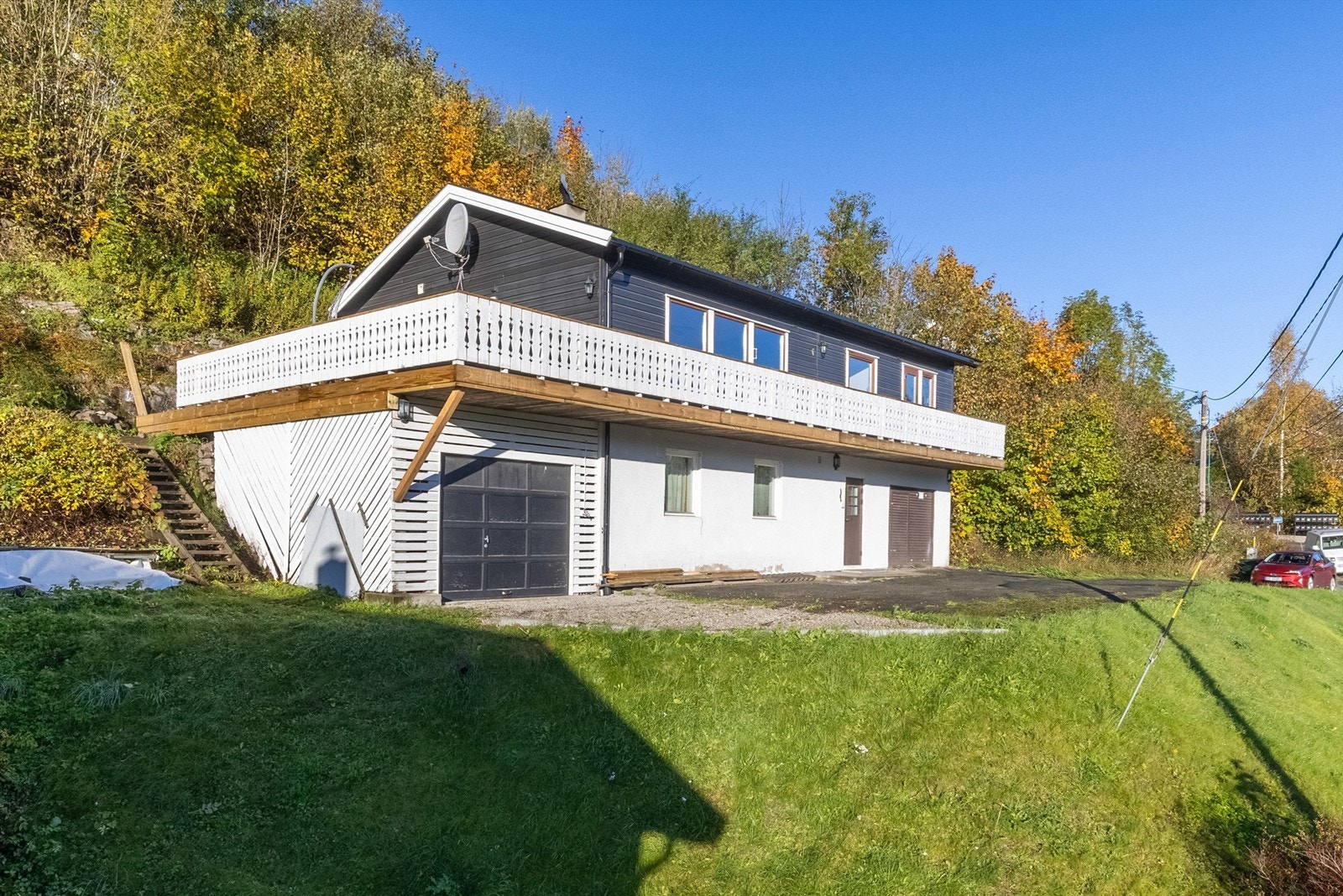 Skrånende tomt som er opparbeidet med gressplen og diverse beplantninger - naturtomt bak boligen Galleribilde