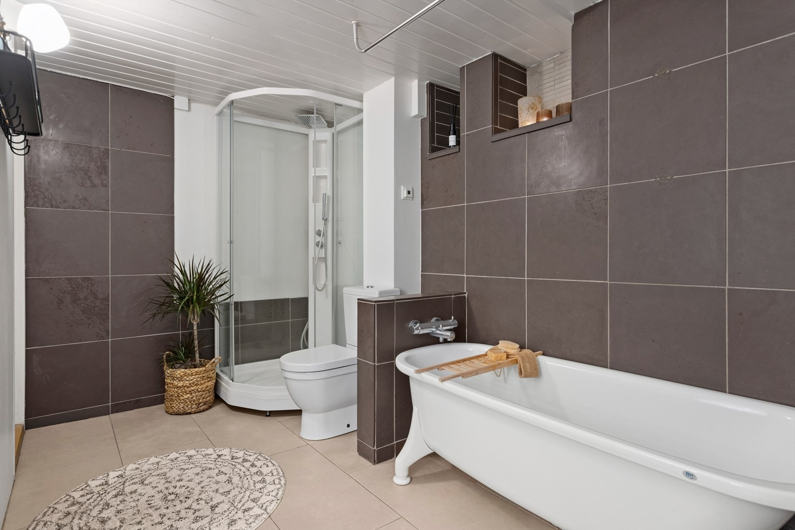 Baderom med dusjkabinet, badekar, servantinnredning med speil og toalett. Galleribilde