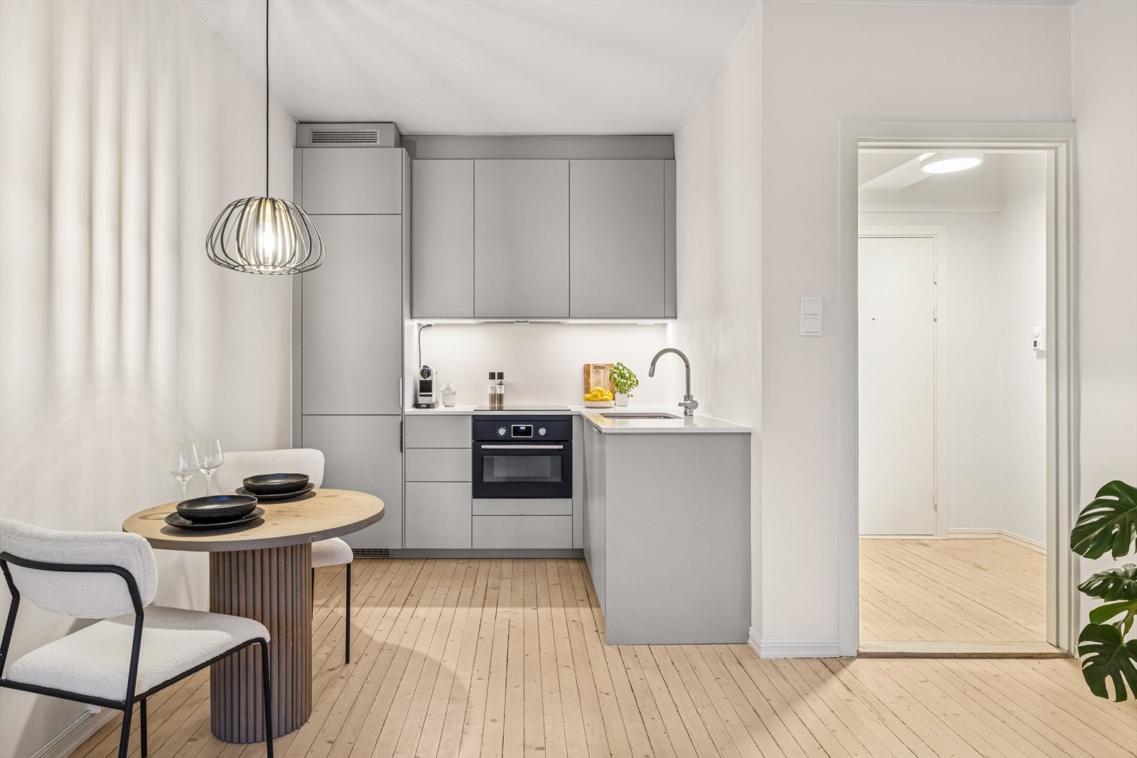 Kjøkkenets innredning har glatte fronter, laminat benkeplate med underlimt kum i rustfritt stål, belysning under overskap og kjøkkenventilator med kullfilter. Galleribilde