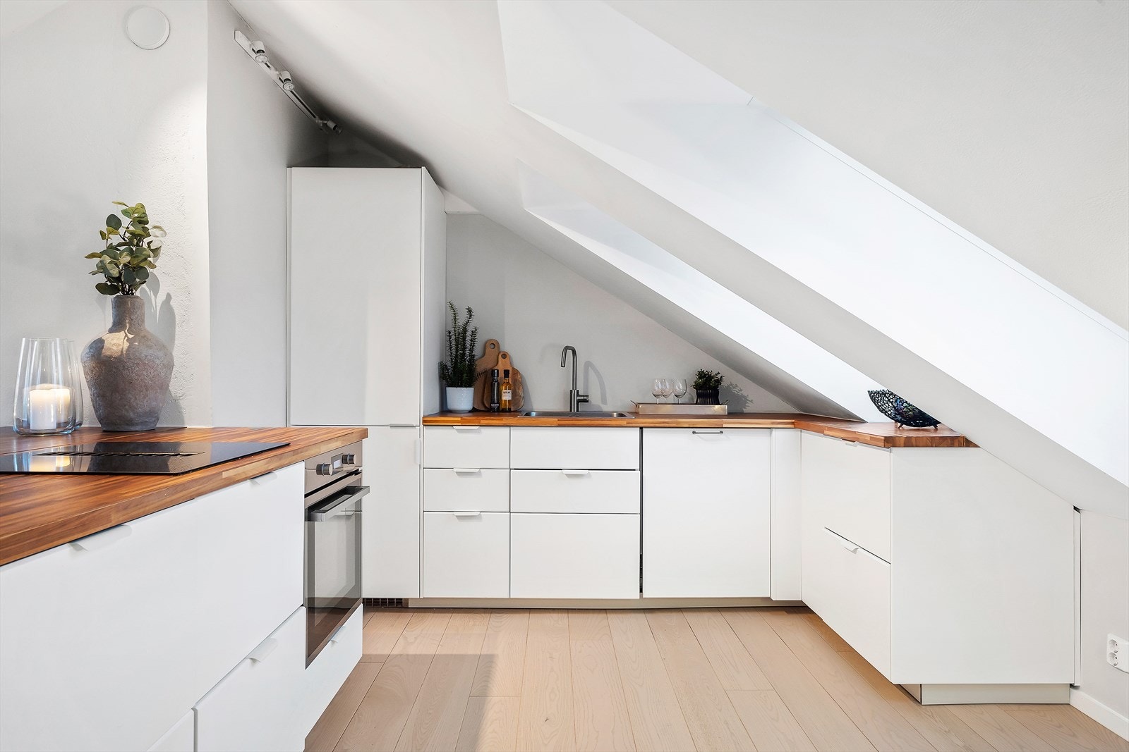 Flott kjøkken med glatte fronter og integrerte hvitevarer. Galleribilde