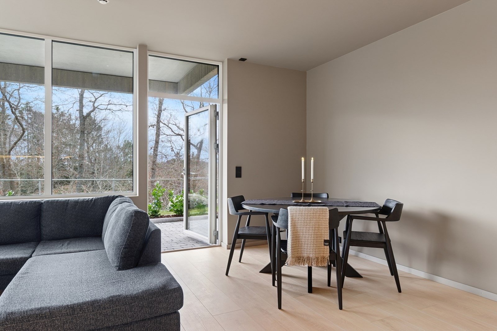 Fra stuen er det utgang til overbygget uteplass med beleggningstein omkranset med hekk. Galleribilde