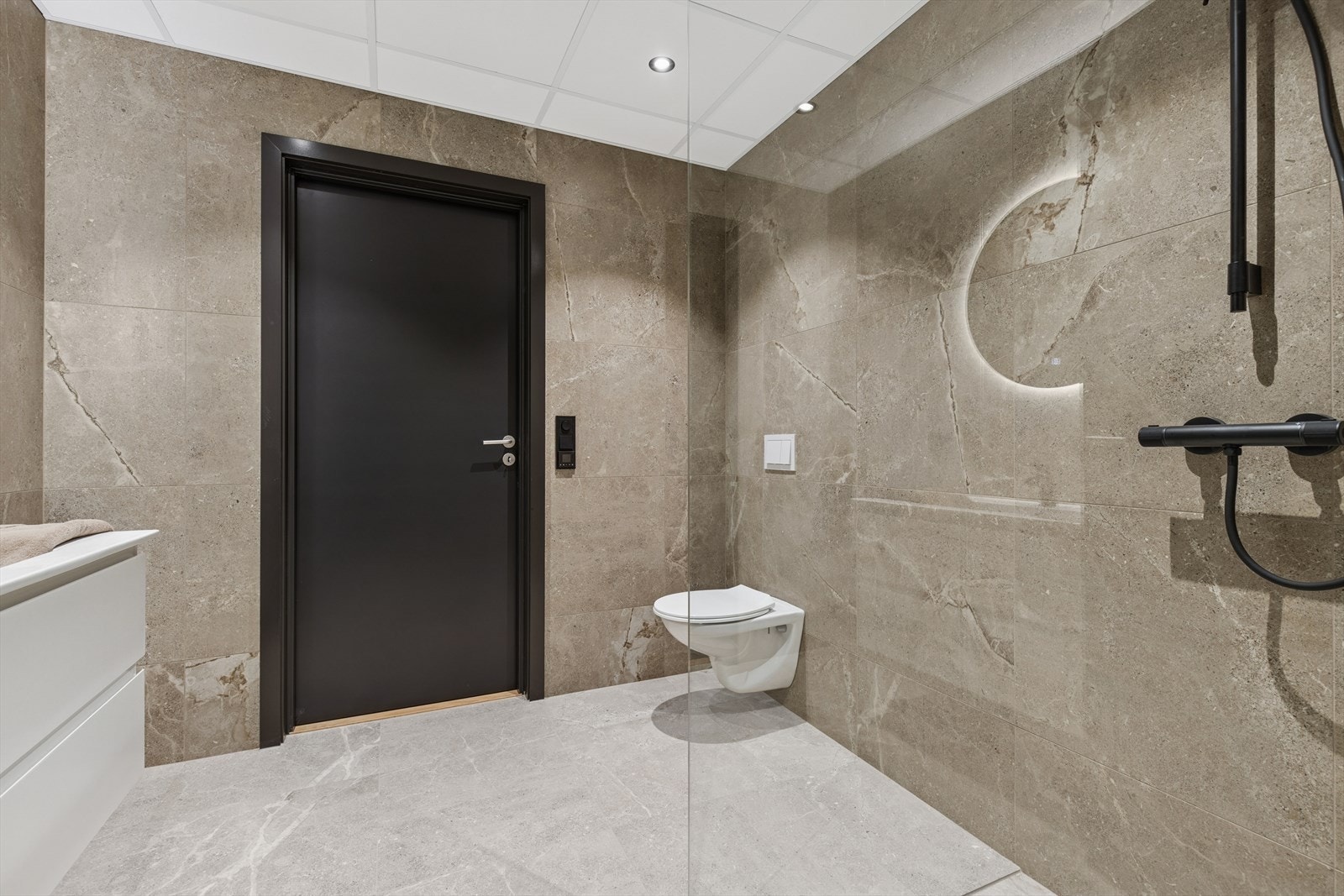 Badet har lekre store fliser på gulv og vegger og elektrisk gulvvarme. Innfelte downligts i himling. Galleribilde