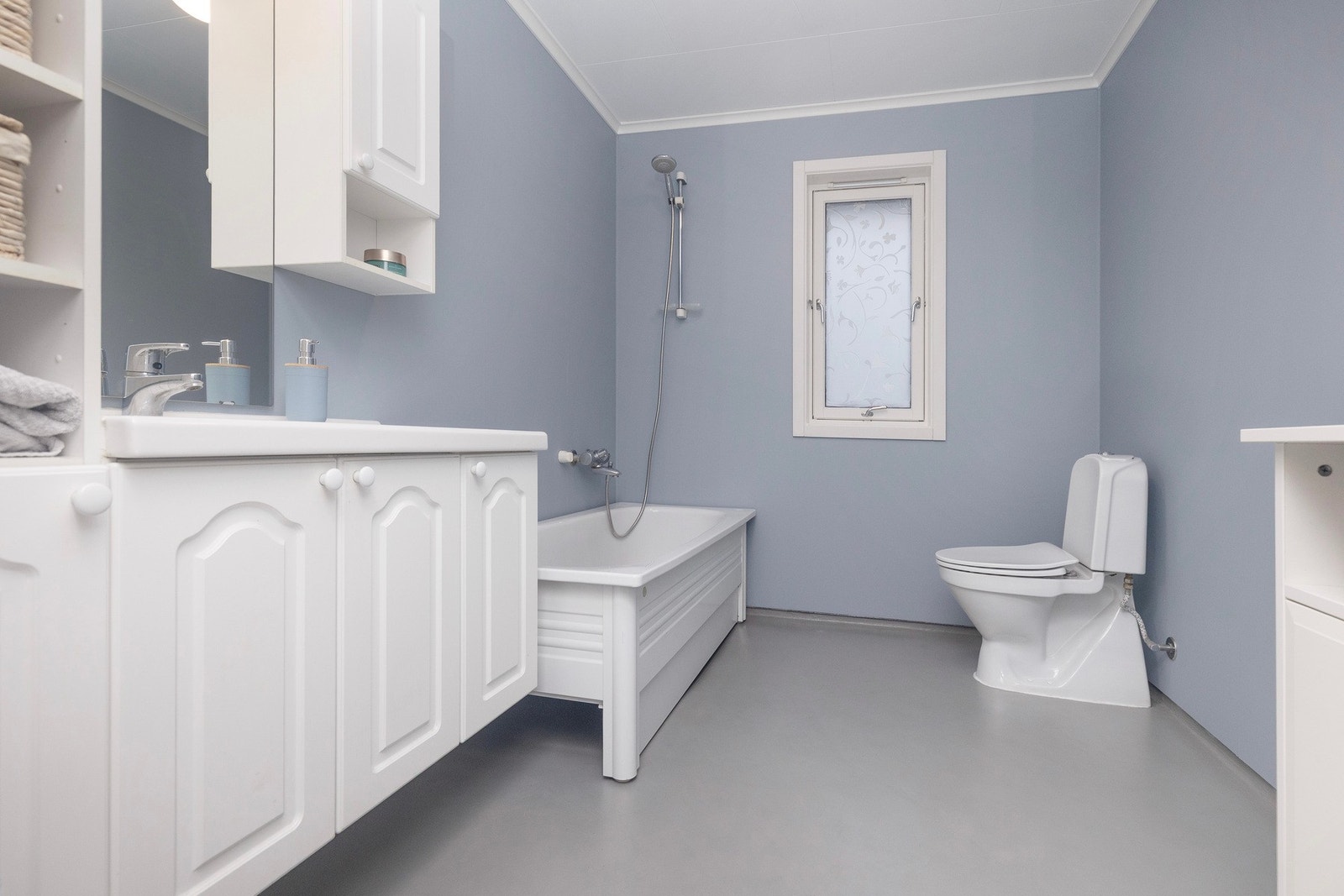 Baderom på ca 6,2 kvm med servant og god skapplass, badekar og toalett. Galleribilde