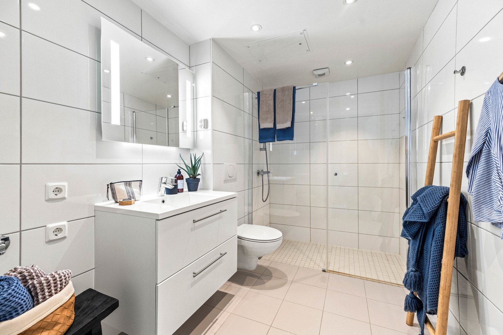 Tidløst baderom med flislagte overflater, gulvvarme og downlights. Galleribilde