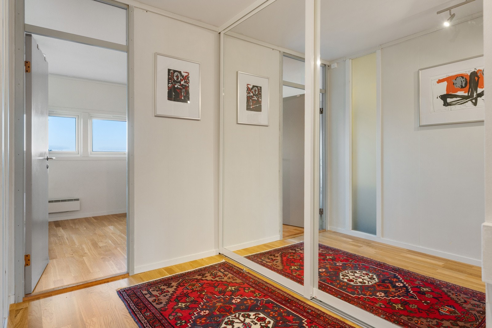 Praktisk skyvedørsgarderobe med speilfronter for oppbevaring i gangen, plassert like ved soverommene. Galleribilde