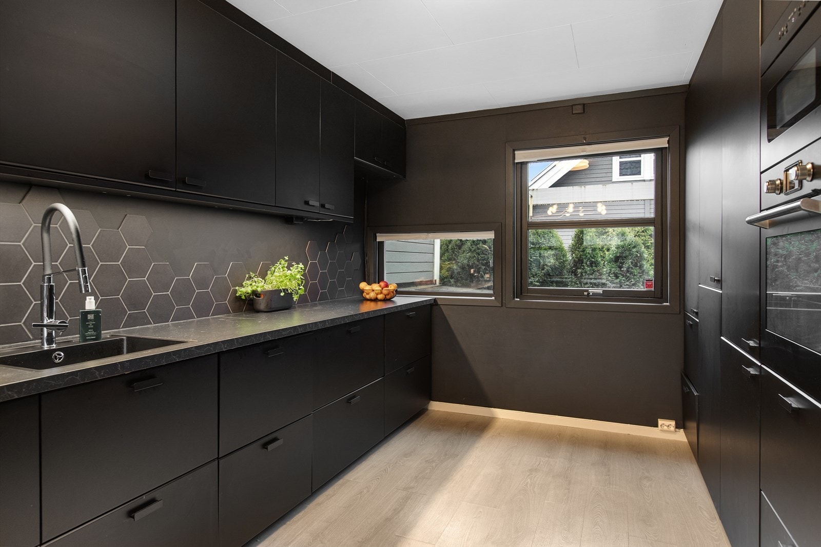 Innredningen har slette, håndtaksløse fronter og integrerte hvitevarer. Galleribilde