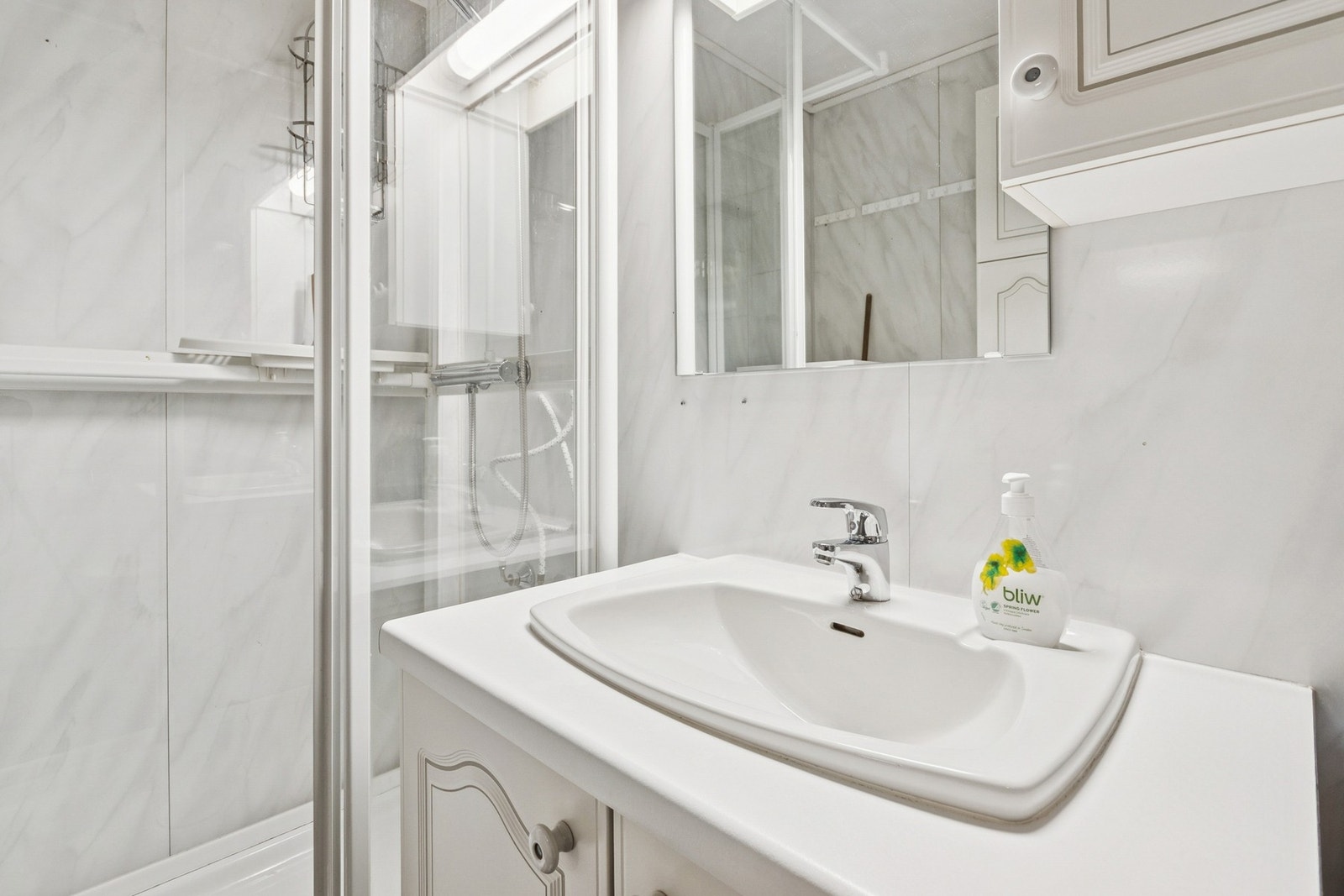 Rommet er innredet med dusjkabinett, toalett, baderomsinnredning med underskap og nedfelt servant, ett overskap med lyskonsoll og ett veggskap. Galleribilde