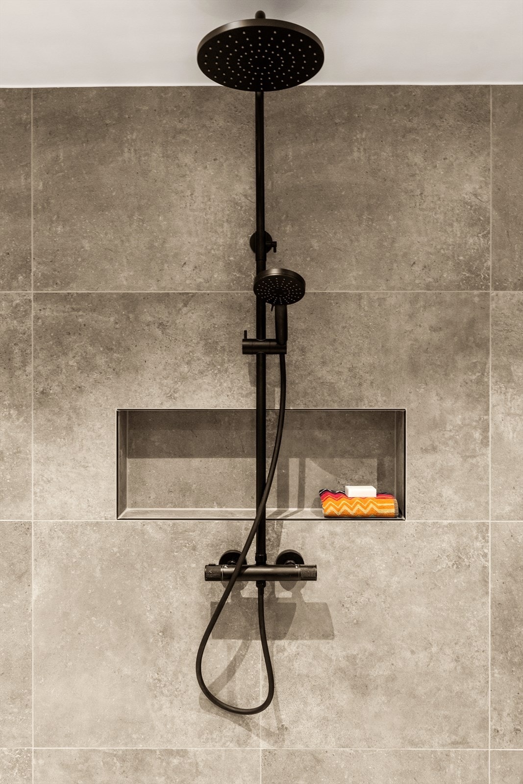 Badet i tilknytning til hovedsoverommet har flislagte overflater på gulv og vegger med elektriske varmekabler i gulv. Galleribilde