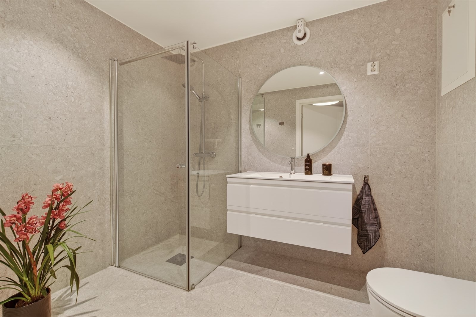 Moderne baderommet holder en høy standard, med store fliser i limestone, dusj med glassvegger og vegghengt toalett Galleribilde