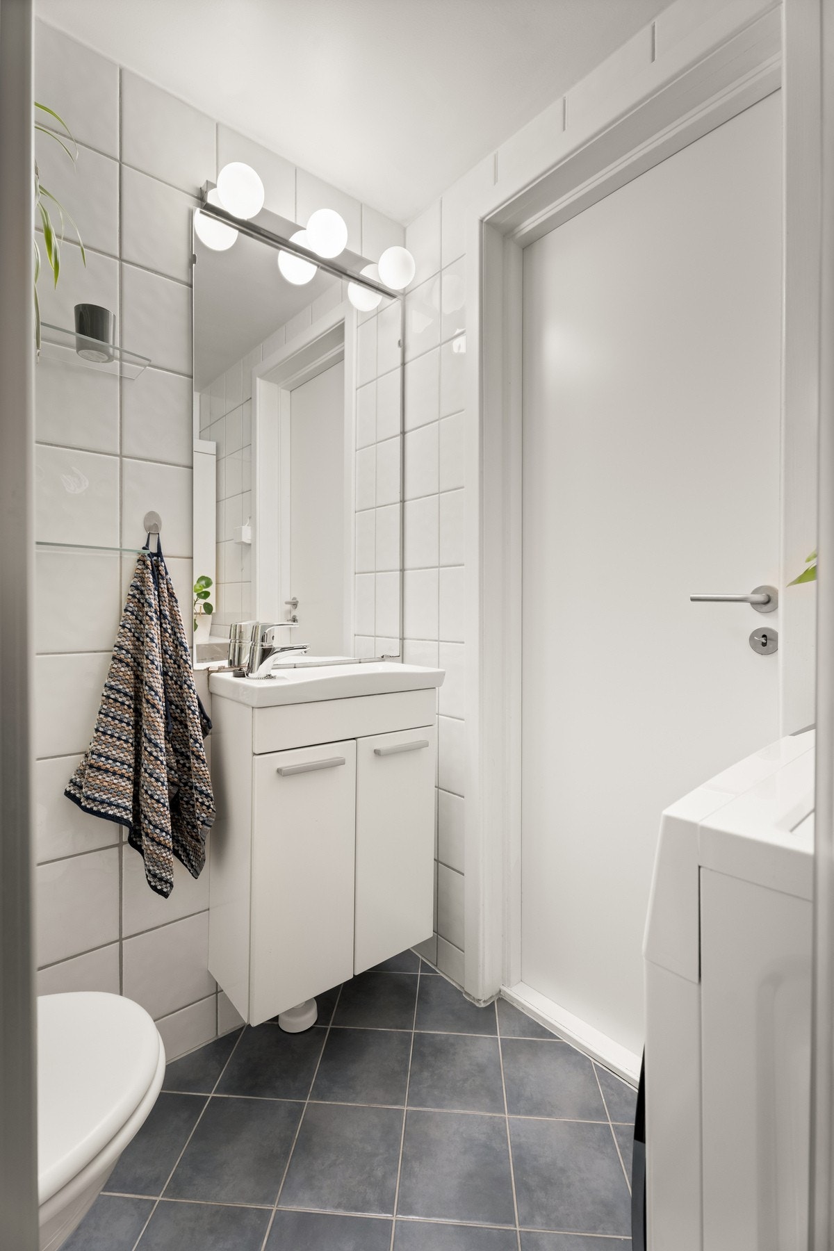 På badet er det vegghengt toalett, benkeskap med servant, opplegg og plass for vaskemaskin Galleribilde