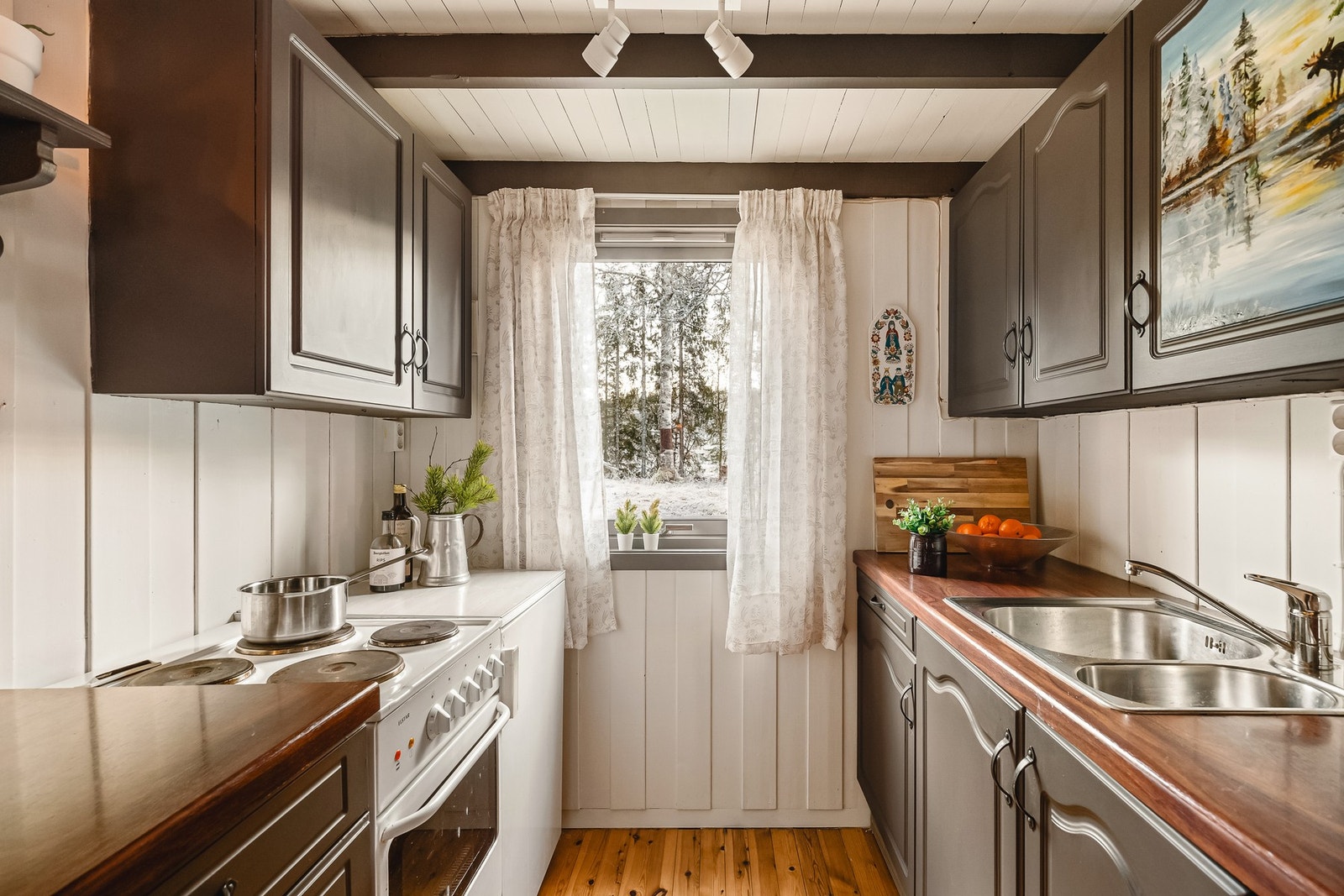 Kjøkkeninnredningen består av slette fronter, stål benkeplate, over benkeplaten er det benyttet panel, stål oppvaskkum. Galleribilde