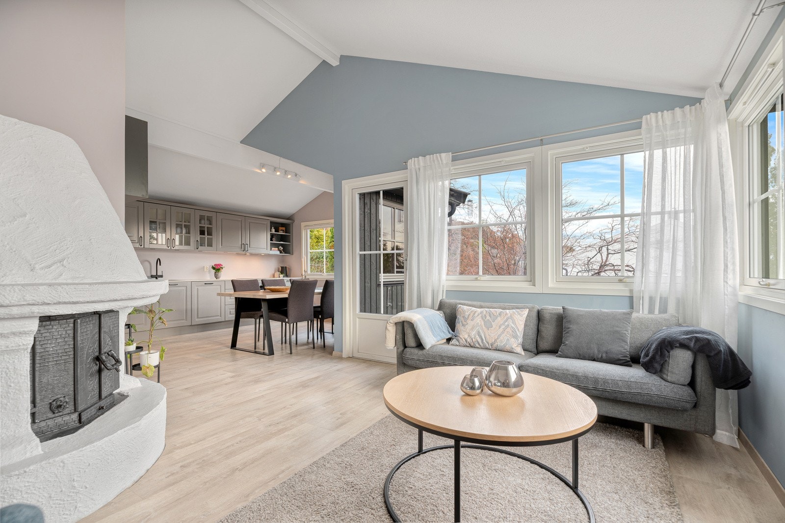 Stue med peisovn og plass til flere sofagrupper Galleribilde