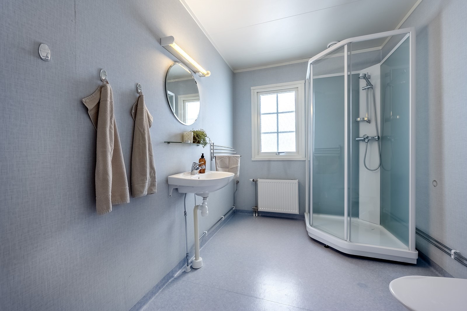 Bad fra byggeår i 1. etasje har dusjkabinett, wc og servant samt plassbygd skap Galleribilde