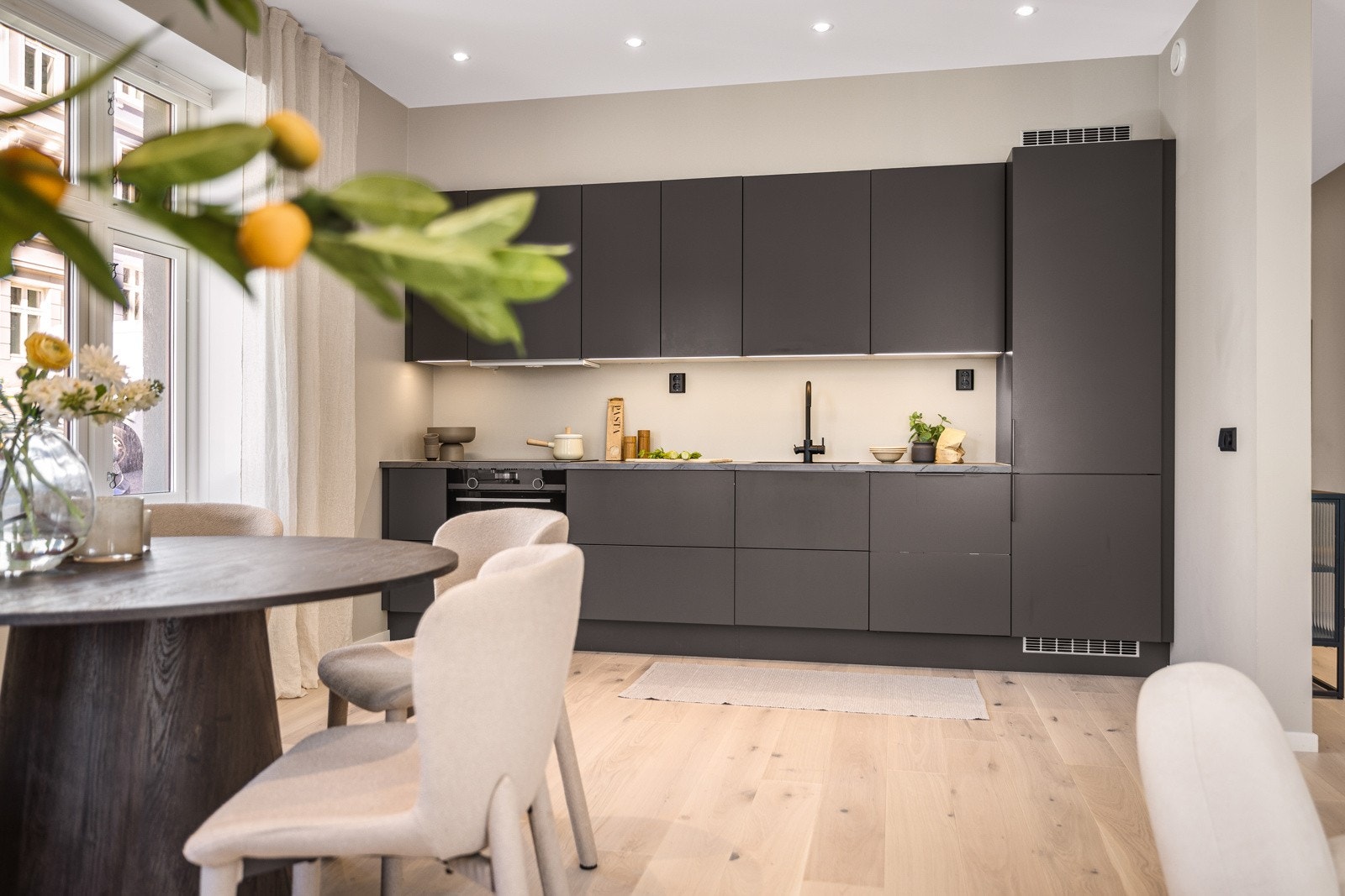 Kjøkkenet inneholder stekeovn, oppvaskmaskin, induksjonsplatetopp og kjøleskap med frys. Galleribilde