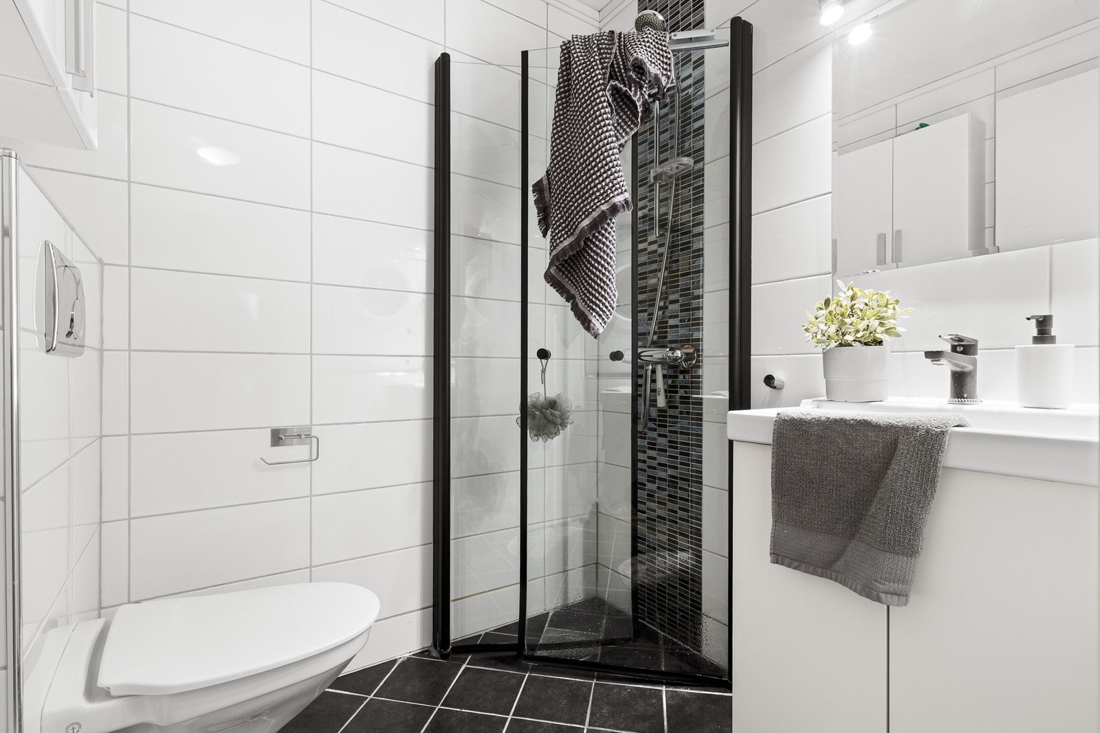 Pent og helfliset bad med varme i gulv. Det er også et praktisk innhuk i veggen på badet hvor vaskemaskinen er plassert. Vaskemaskinen medfølger. Galleribilde