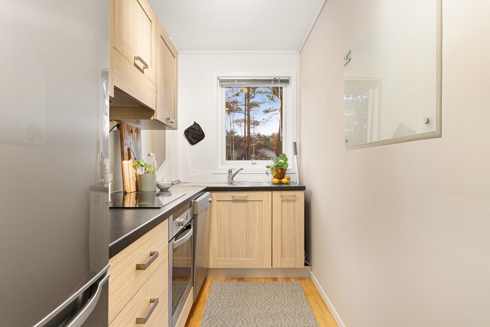 Profilerte fronter med laminat benkeplate. Kjøkkenet er utstyrt med stekeovn, platetopp, oppvaskmaskin og kjøleskap. Alle hvitevarer medfølger. Galleribilde