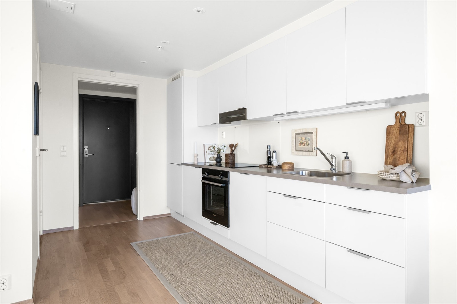 Hvitevarene er sømløst integrert i innredningen og består av platetopp, stekeovn, oppvaskmaskin og kjøl-/fryseskap. Galleribilde