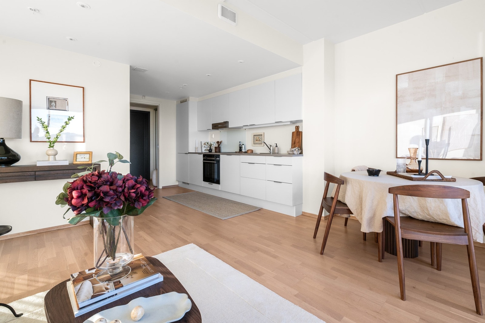 Åpen og moderne kjøkkenløsning med glatte fronter og en helhetlig, stilren utforming. Galleribilde