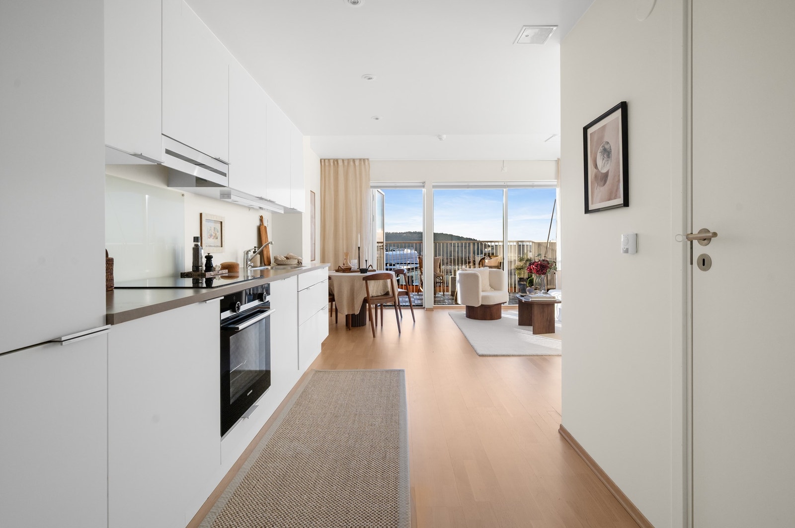 Fra entréen åpner boligen seg direkte mot kjøkken og stue, med badet lett tilgjengelig til høyre. Galleribilde