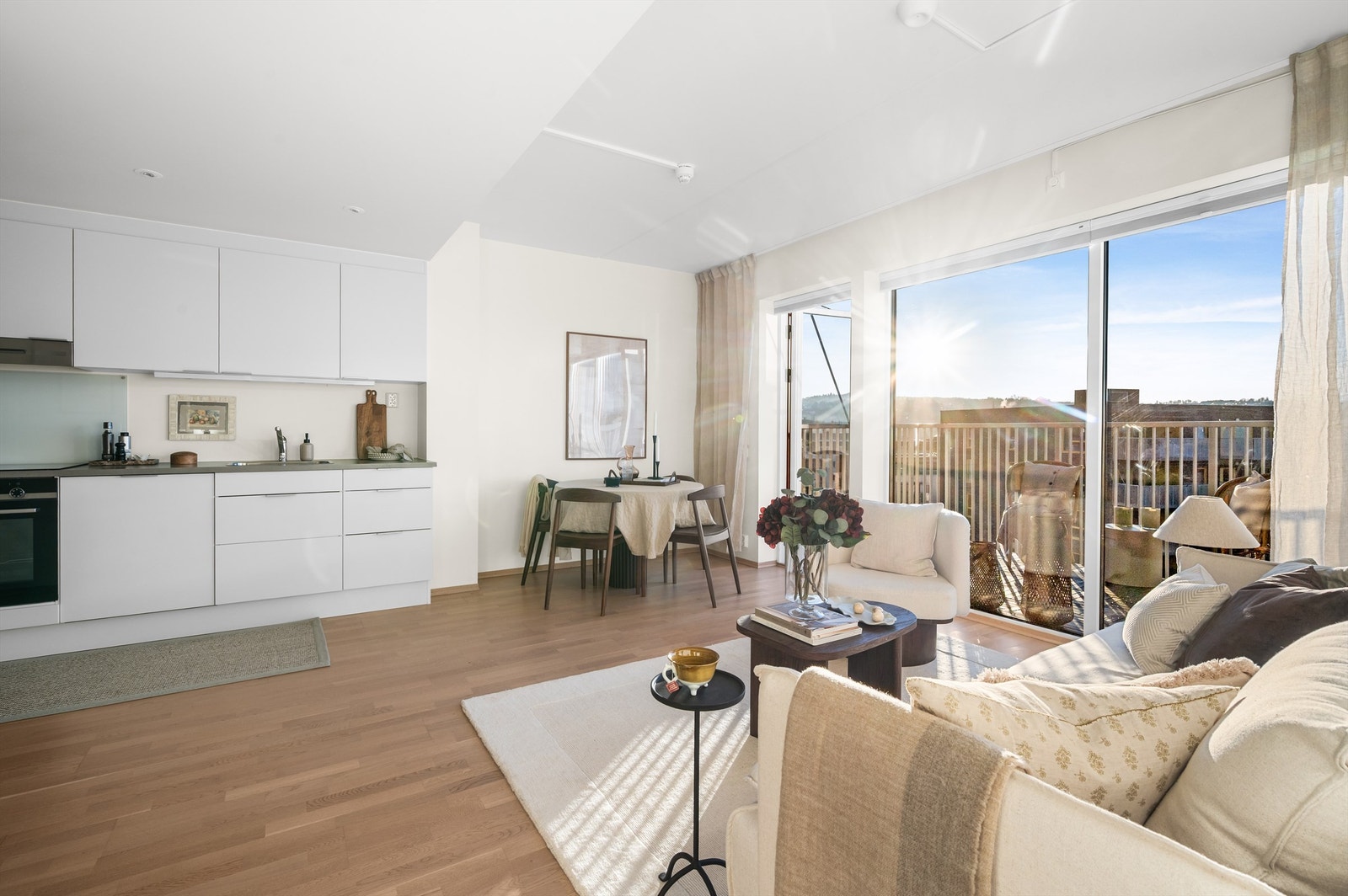 Den åpne løsningen mot kjøkkenet skaper et sosialt og sammenhengende oppholdsrom, godt egnet for hyggelige sammenkomster med familie og venner. Galleribilde