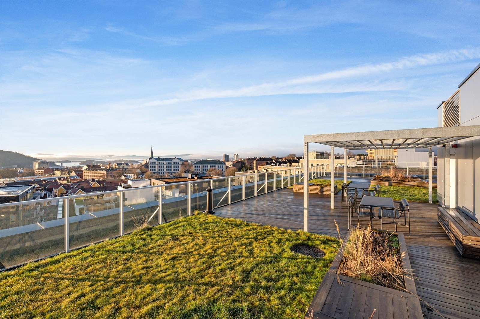 Takterrassen er pent opparbeidet med grøntarealer og innbydende sittegrupper. Galleribilde