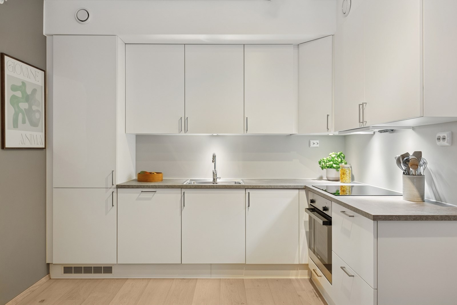 Stilrent og lekkert kjøkken med integrert kombiskap, oppvaskmaskin, platetopp og stekeovn. Galleribilde