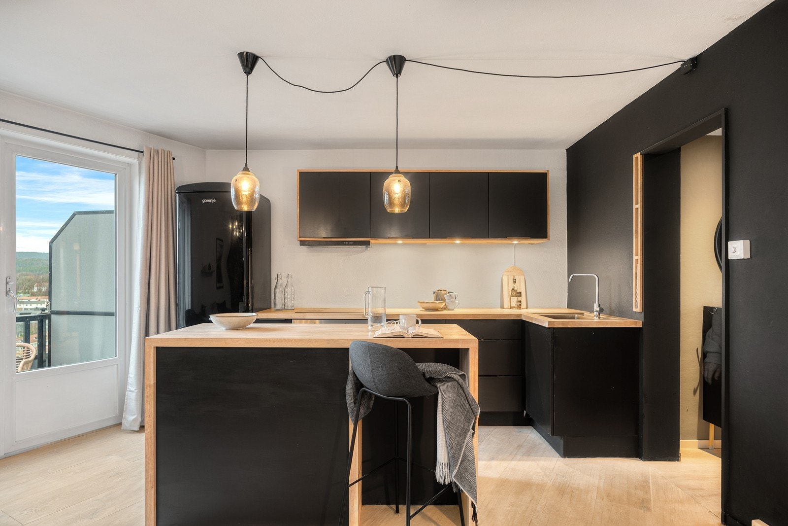 Kjøkkenet har slette fronter og benkeplate av heltre, samt en praktisk kjøkkenøy for mer arbeidsplass Galleribilde