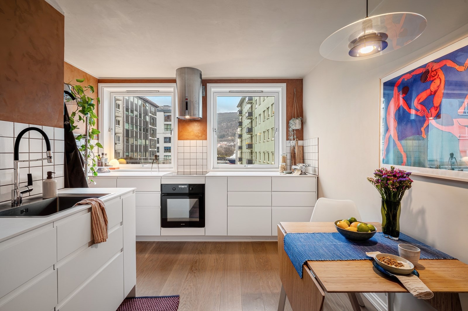 Kjøkkeninnredning fra IKEA, montert i 2021, med moderne glatte fronter og benkeplate i kompaktlaminat som gir en slitesterk og praktisk arbeidsflate. Nedfelt stålvask med ettgreps blandebatteri og fliser over benkeplate. Galleribilde