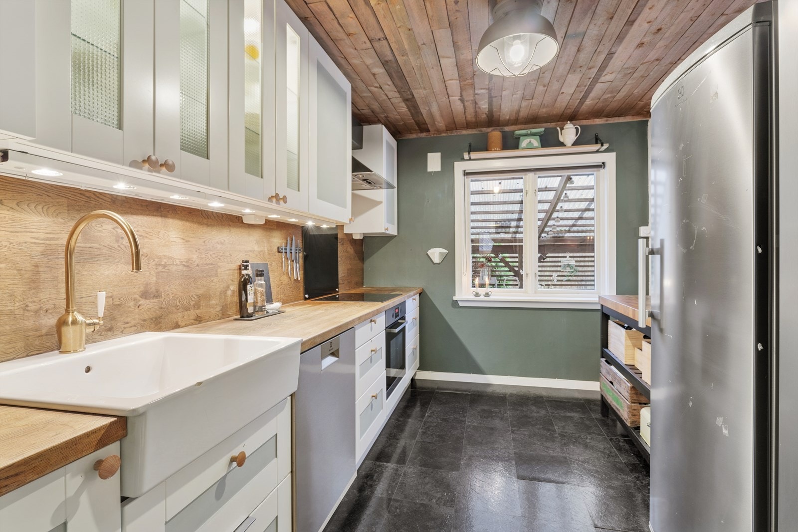 Kjøkkenet har lettstelt belegg på gulv og er for øvrig holdt i nyanser som kler boligens landlige beliggenhet Galleribilde