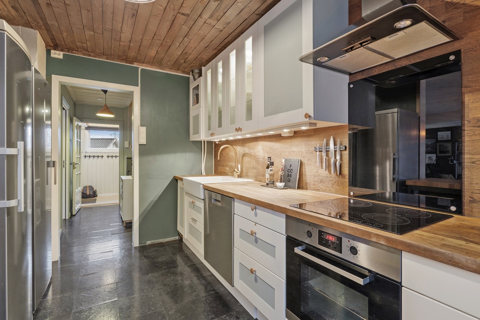 Kjøkkenet er romlig med mye skap og benkeplass Galleribilde