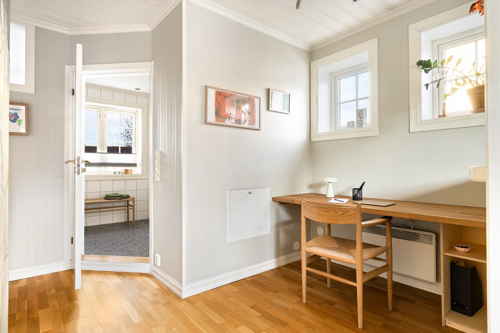 Velordnet gang med god belysning og plass til en liten arbeidskrok. Galleribilde