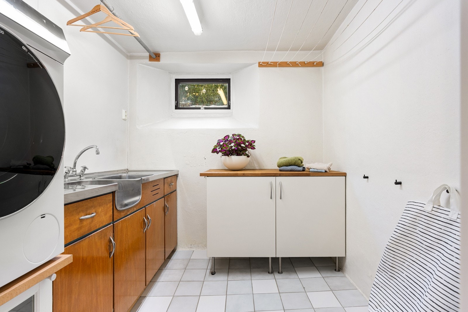 Praktisk vaskerom med servant og opplegg for vaskemaskin. Galleribilde