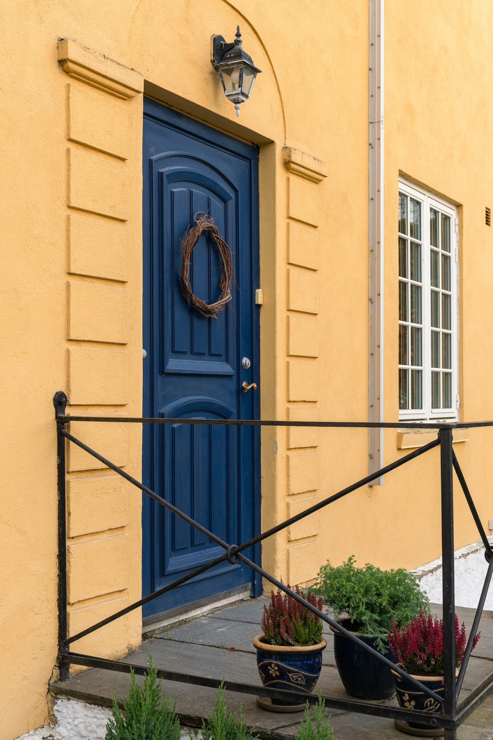 Innbydende inngangsparti med klassisk blå tredør som skaper et sjarmerende førsteinntrykk. Galleribilde