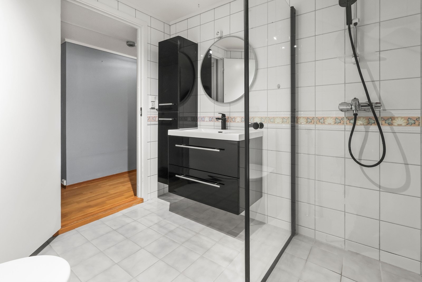 Sort høyglans baderomsinnredning og dusjhjørne. Opplegg for vaskemaskin. Galleribilde