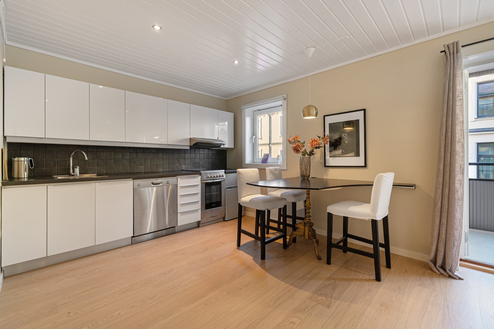 Kjøkkenet er utstyrt med kjøl-/fryseskap, oppvaskmaskin og komfyr, og har en funksjonell innredning med glatte fronter. Galleribilde