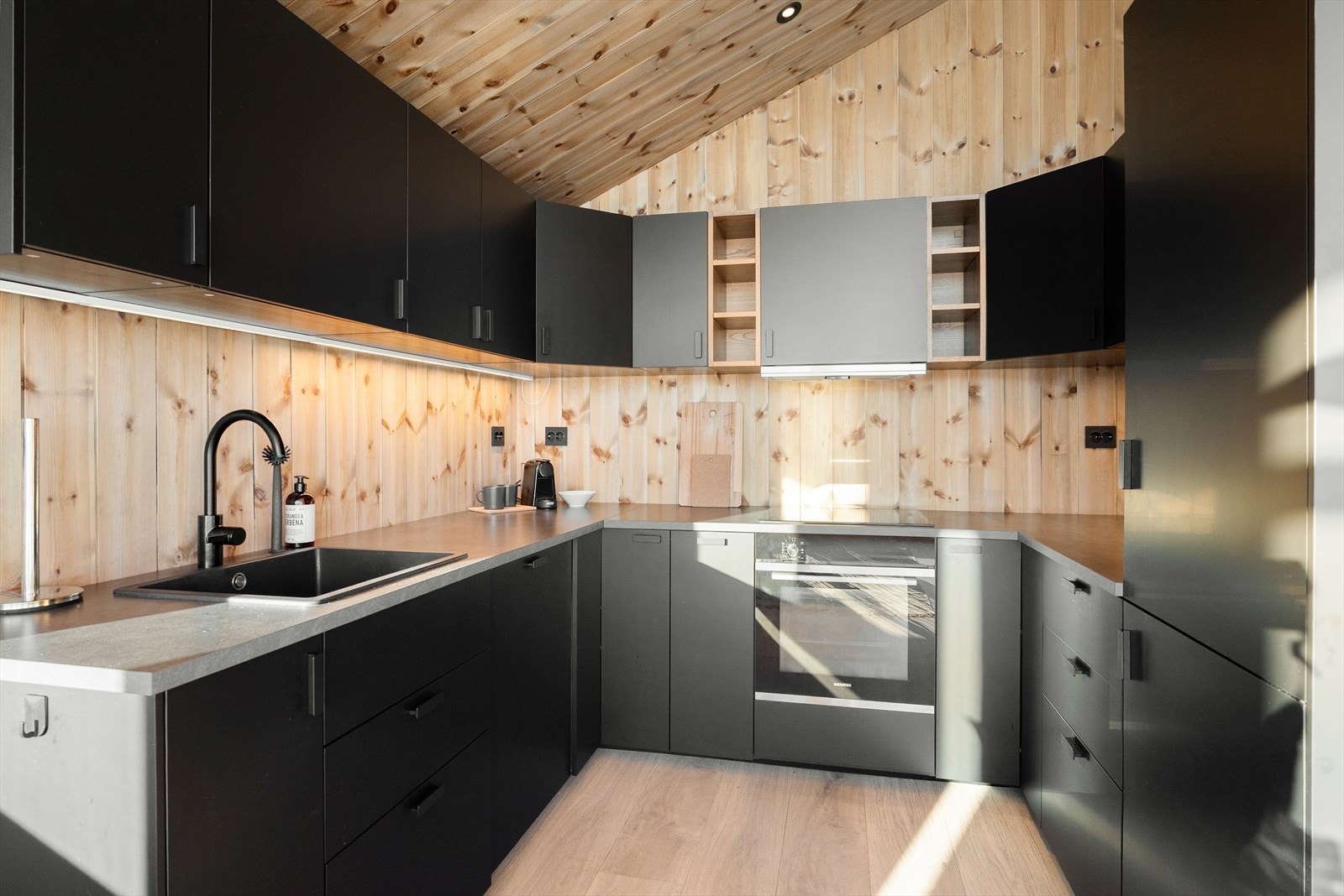 Lekker kjøkkeninnredning i mørk utførelse med god oppbevarings- og arbeidsplass. Kjøkkenet har integrerte hvitevarer i form av stekeovn, platetopp, oppvaskmaskin og kjøleskap/frys. Galleribilde