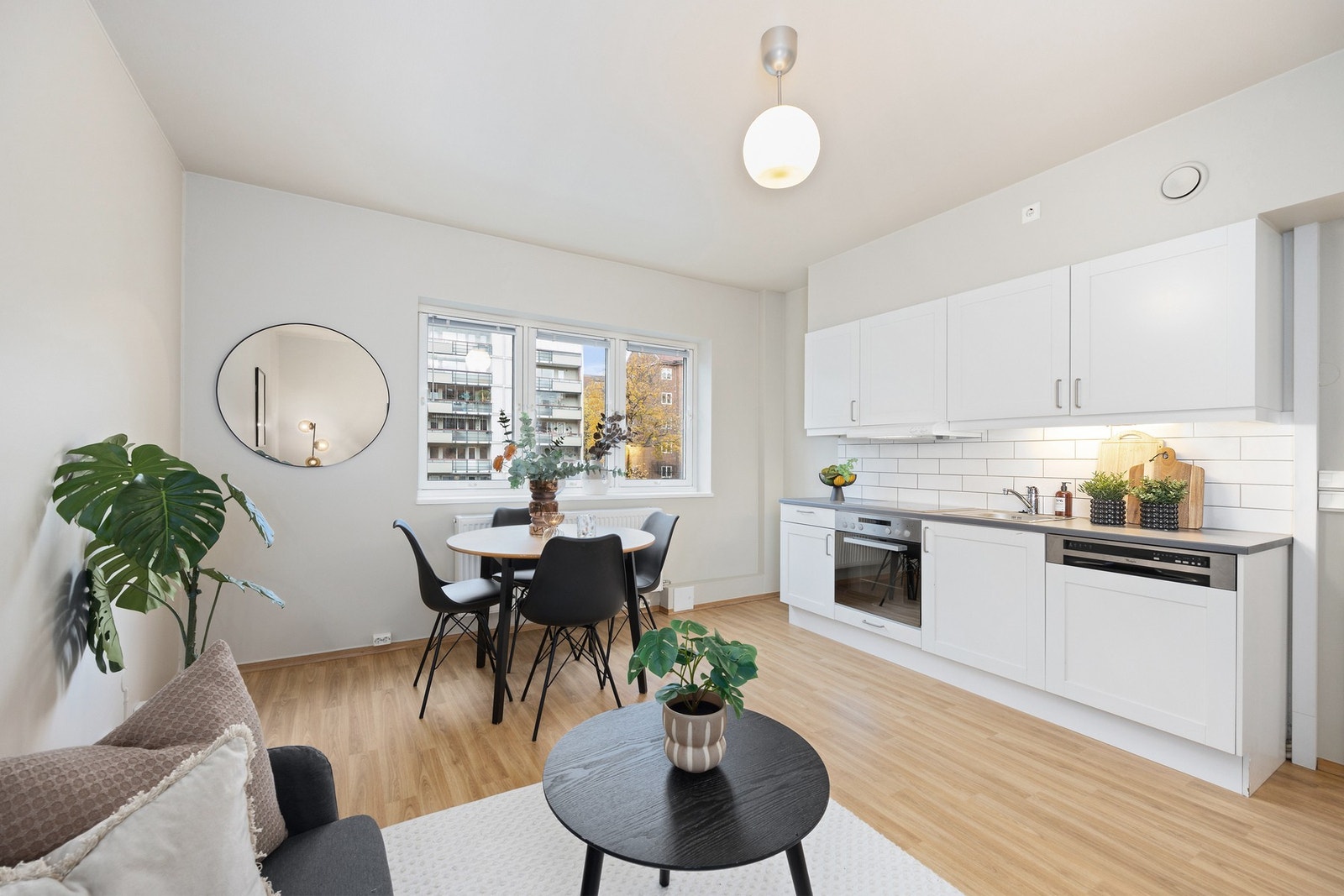 Kjøkkeninnreding med hvite profilerte fronter. Hvitevarene medfølger og det er plass for kjøleskap i hjørnet til venstre. Galleribilde