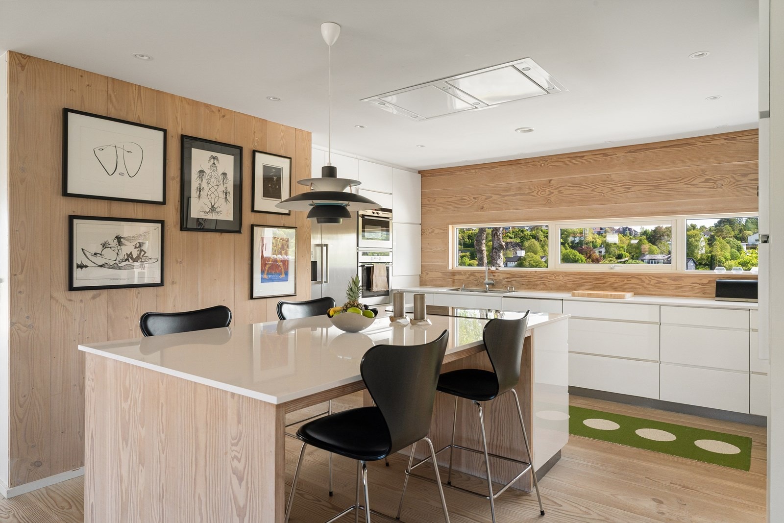 Kjøkkeninnredning med lyse glatte fronter og kompositt benkeplate. Galleribilde